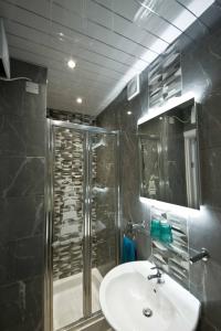 ein Bad mit einem Waschbecken und einer Dusche in der Unterkunft Rossall House , For Families & Couples in Blackpool