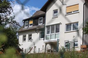 a white house with a black roof at Ferienwohnung Am Sonnenhang Blecher in Bad Laasphe +5 photos