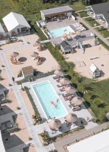 an overhead view of a swimming pool with people and umbrellas at Pastelowe Domki Darłówko in Darłówko