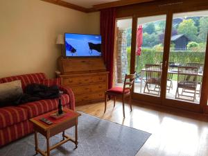 a living room with a couch and a flat screen tv at Studio - La Vièze Thermes Park in Val-d'Illiez