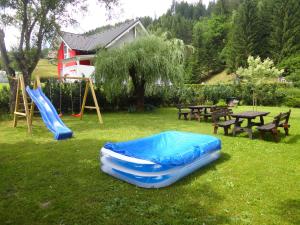 einen Spielplatz mit zwei aufblasbaren Rutschen, einem Tisch und Bänken in der Unterkunft Hotel Sonnleitn in Jenig
