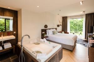Schlafzimmer mit Badewanne und Bett in der Unterkunft Van Heeckeren Hotel in Nes