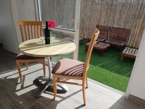a table and two chairs with a bottle and a wine glass at חאן בכפר במשק בלה מאיה - הצימר in Nevatim