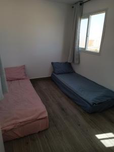 a room with two beds and a window at חאן בכפר במשק בלה מאיה - הצימר in Nevatim