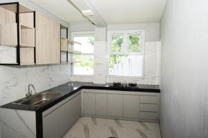 a white kitchen with a sink and a window at Villa Languket in Bedoyo