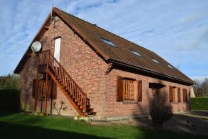 Una pequeña casa de ladrillo con una escalera. en Les chambres d hôtes de l entre deux baies à Merlimont entre Berck et le Touquet, en Merlimont