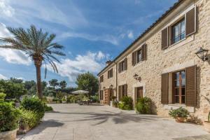 a stone building with a palm tree next to it at Cadell Gran in Sa Pobla