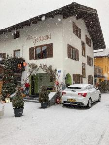 オエッツにあるHaus Gertraudの雪中の建物の外に置かれた白車