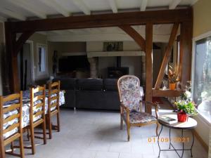 a living room with chairs and a table and a couch at Les 2 chaumières avec piscine in Épinay