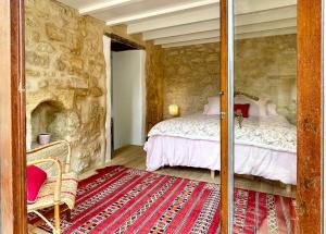 a bedroom with a bed in a stone wall at Le Tilleul in Grézillac