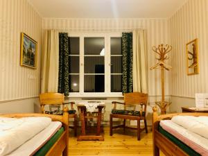 EdsbynSTF Vandrarhem Edsbyn的一间卧室，有两张床、一张桌子和一扇窗户