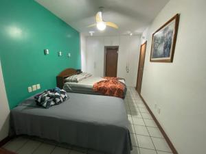 2 camas en una habitación con paredes verdes en Apartamento Barra Tropical Residence, en Salvador