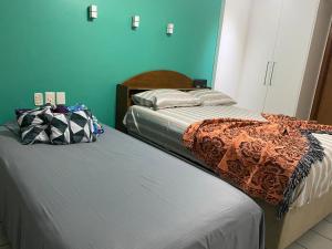 dos camas sentadas una al lado de la otra en un dormitorio en Apartamento Barra Tropical Residence, en Salvador