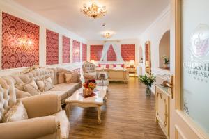 a large living room with couches and a chandelier at Schlosshotel Klaffenbach in Chemnitz