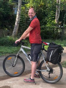 a man is standing next to a bike at Summer Ridge - Homestay in Ratnapura