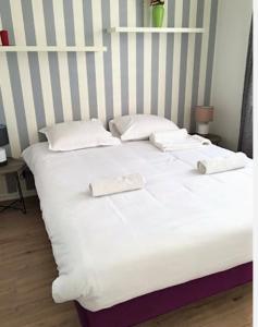 een groot wit bed met 2 handdoeken erop bij Apartment balcon & parking in Serris