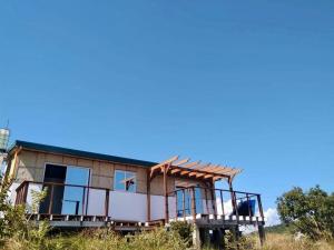 una casa con un porche envolvente en Masamirey Hilltop Cottage Seaview with Private White Beach Access, en Sual