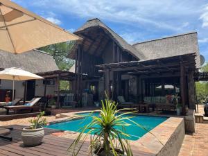 a house with a swimming pool and a patio at Ujabule Lodge in Hoedspruit