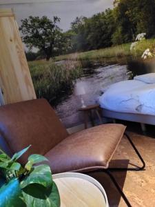 a room with two beds and a view of a river at Herberg De Eexter Os in Eext