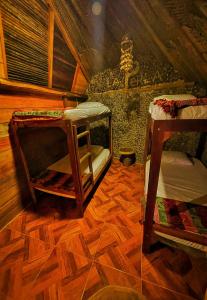 a room with two bunk beds and a wooden floor at La Perla Tayrona in El Zaino