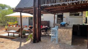 a patio with a table and an umbrella at Ujabule Lodge in Hoedspruit
