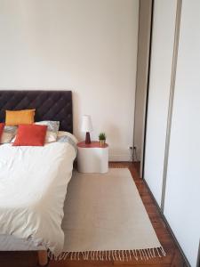 a bedroom with a bed with a rug next to a window at Anna's Home Sweet Home in Boulogne-Billancourt