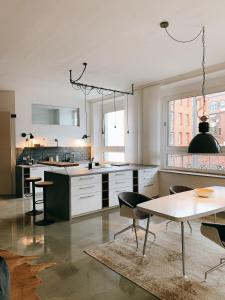 eine Küche mit weißen Schränken und einem Tisch und Stühlen in der Unterkunft GOHO Loft in Nürnberg