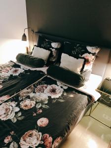 ein Schlafzimmer mit einem Bett mit geblümter Tagesdecke in der Unterkunft GOHO Loft in Nürnberg