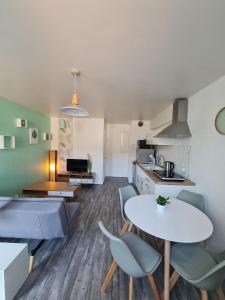 cocina y sala de estar con mesa y sillas en Gîte "Côté Terre", avec piscine chauffée, en La Roche-sur-Yon