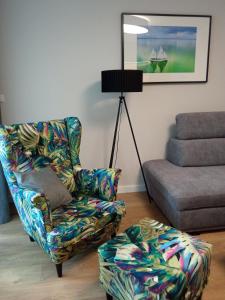 sala de estar con silla y reposapiés en Apartamenty Woda i Las, en Turawa