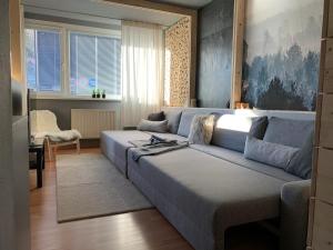 una sala de estar con un sofá azul en una habitación en Apartmán Pinus, en Donovaly