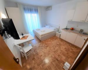 a small white room with a desk and a bed at Pension Alba in Podstrana