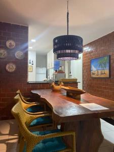 a kitchen with a large wooden table and chairs at Casa em Tamandaré-Carneiros CondFechado a 100m do mar in Tamandaré