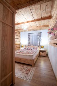 ein Schlafzimmer mit einem Bett und einer Holzdecke in der Unterkunft Chata Litwor in Bukowina Tatrzańska