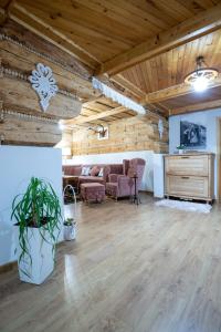 un ampio soggiorno con soffitti in legno e pavimenti in parquet di Chata Litwor a Bukowina Tatrzańska