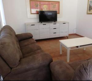 sala de estar con sofá, TV y mesa en Samoa Beach en Arenella