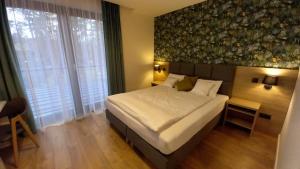 a bedroom with a large bed and a large window at Apartamenty Woda i Las in Turawa