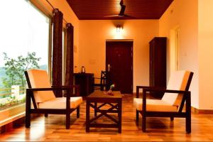 a living room with two chairs and a table at Heaven Valley Resorts Vagamon in Vagamon +94 photos