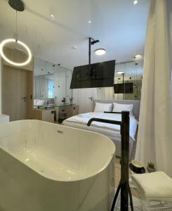 ein Badezimmer mit einer Badewanne neben einem Bett in der Unterkunft ConnectIN Apartments in Pale
