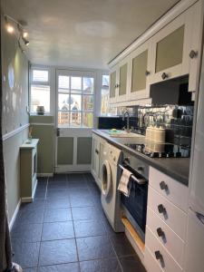 a kitchen with a washer and dryer in it at Chapel Cottage Idylic Village Holiday Home in Box