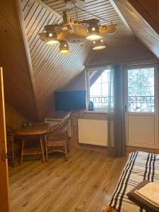 um quarto com um tecto com uma mesa e uma janela em Писанка Плюс em Yaremche