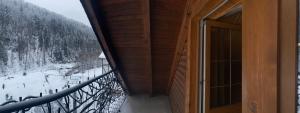 einen Balkon mit Blick auf einen schneebedeckten Wald in der Unterkunft Писанка Плюс in Jaremtsche