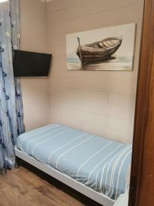 a small bedroom with a bed and a picture of a boat at B&B Empire 1970 in Trieste