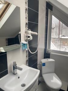 Łazienka z białą toaletą i umywalką w obiekcie Писанка Плюс w Jaremczach