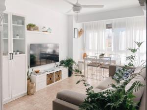 a living room with a couch and a flat screen tv at Apartament Ampolla Port in L'Ampolla