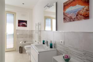 een witte badkamer met een wastafel en een toilet bij La Perla in Taormina +16 foto's
