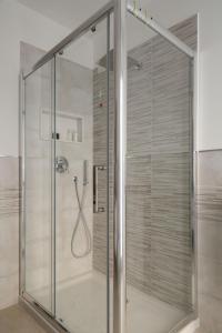 een douche met een glazen deur in een badkamer bij La Perla in Taormina