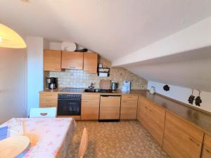 una cocina con armarios de madera y una mesa en una habitación en InnValleyInn, en Brannenburg