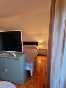 Dormitorio con cama y tocador con TV en InnValleyInn, en Brannenburg