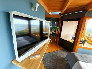 クニスナにあるLagoon Studio - Fantastic Knysna Lagoon views and SOLARのベッドルームに大画面薄型テレビが備わります。